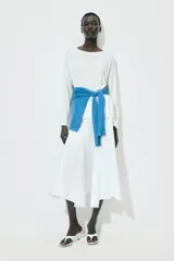 Jersey de punto liso, color azul brillante, con cuello redondo y manga larga. Presenta acabados en rib en puños, cuello y bajo, con aberturas laterales en el ruedo.