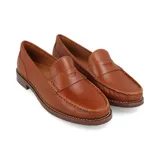 Mocasín de cuero color suela, con diseño clásico tipo penny loafer, costuras reforzadas en el empeine y suela de madera con tacón bajo.