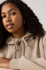 Hoodie color taupe con capucha ajustable mediante cordones, bolsillo canguro frontal y logo pequeño de Levi's en el pecho.