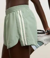 Bermuda deportiva femenina modelo runner color verde menta, con cintura elástica y diseño holgado con bajo redondeado.