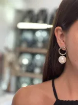 Aros colgantes con un aro pequeño plateado del que cuelga una perla grande.