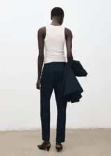 Pantalón estilo traje de corte recto y tiro medio, color azul marino, con bolsillos laterales y traseros, y cierre frontal oculto.