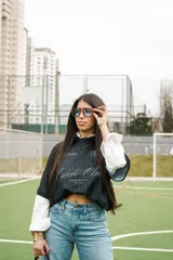 Camiseta de fútbol estilo boxy de manga corta y cuello polo, en color negro con sutiles rayas verticales. Presenta inscripciones estampadas y escudo bordado en el pecho.