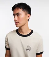 Remera color beige de algodón, modelo baby tee, con cuello y mangas con ribete negro. Estampa en el pecho con la frase "Boys Should Cry".