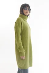 Vestido tipo sweater color beige, de tejido de punto acanalado, corte recto, largo a la rodilla y cuello alto.