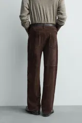 Pantalón de corte straight fit confeccionado en ante de color marrón, con diseño de cinco bolsillos y cierre frontal con cremallera y botón.