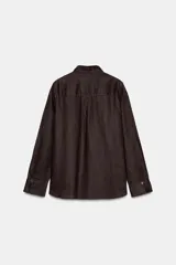 Camisa color coral confeccionada en lino 100%, de corte recto, con cuello solapa, manga larga con puños abotonados y cierre frontal con botones.