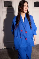 Blazer azul de lino con corte holgado, solapas y cuatro botones fucsia.