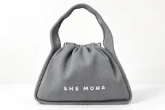Cartera de mano gris de nylon acanalado, con cierre de cordón ajustable, asa superior y logo de la marca en relieve en el frente.