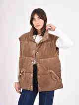 Chaleco acolchado de pana color marrón, diseño puffer sin mangas con cuello alto y cierre frontal de botones a presión.