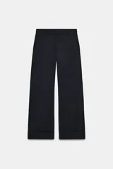 Pantalón de tiro medio confeccionado en lana 100%, con corte de pierna recta y bajo con vuelta. Presenta cintura con trabillas, cierre frontal con cremallera, botón y ganchos metálicos, además de bolsillos laterales y traseros.