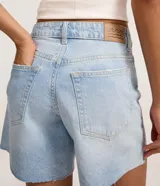Bermuda de cintura mediana confeccionada en jean, con trabillas en la cintura, cierre tradicional, bolsillos y bajo deshilachado.