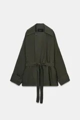 Trench corto de Zara, confeccionado en mezcla de lyocell, color verde militar. Presenta cuello solapa, manga larga con hombro caído y puños con trabilla. Incluye bolsillos delanteros de plastrón, cierre frontal cruzado con botón y cinturón de lazada en el mismo tejido.