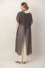 Maxi blusón negro de seda con diseño asimétrico en picos y mangas cortas fluidas.