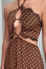 Vestido largo de estilo boho con estampado paisley en tonos tierra, naranjas y azules. Presenta un top tipo halter con espalda descubierta y elástica, y una falda larga con caída fluida y elástico en la cintura.