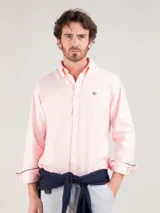 Camisa lisa de hombre confeccionada en algodón, tintada en prenda con acabado vintage. Presenta corte regular fit, cuello buttondown, cierre frontal de botones, manga larga con puño simple y logo bordado en el pecho.