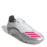 Championes de fútbol Adidas modelo F50 Messi Club, diseñados para terreno firme y césped artificial. Presentan una capellada sintética en color blanco con detalles en plateado, negro y fucsia, incluyendo la inscripción Messi en el lateral y las icónicas tres tiras de la marca.