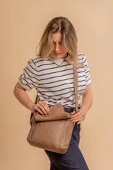 Bandolera de diseño simple con tapa frontal, confeccionada en material símil cuero. Cuenta con correa ajustable, división interna y bolsillos internos para mayor organización.