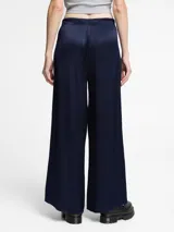 Pantalón de corte ancho y silueta fluida, confeccionado en tejido con textura arrugada y cintura elástica.