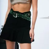 Minifalda de denim celeste con diseño plisado en la parte inferior y bolsillos traseros.