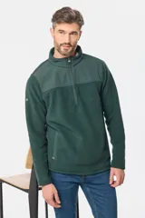 Buzo de micro polar con interior térmico, cuello alto y cierre frontal parcial. Presenta paneles de taslón al tono en el frente y cuello, con bolsillos laterales con cierre y detalle de logo en la manga.