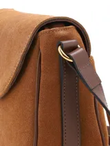 Cartera bandolera de gamuza marrón claro con solapa frontal, detalles de cuero liso más oscuro en los bordes y en el cierre de hebilla metálica dorada. Incluye correa ajustable de hombro.