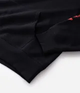 Buzo con capucha de corte relajado, color negro, con estampado frontal y en la manga con el logo de la banda Slipknot en tonos rojos y azules.