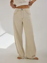 Pantalón de tiro medio alto, color beige, con bolsillos delanteros y traseros. Presenta detalles de atraques y triples costuras en color amarillo. Confeccionado en una mezcla de lino, algodón y viscosa.