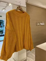 Sweater mostaza tejido con diseño de ochos y cuello redondo.