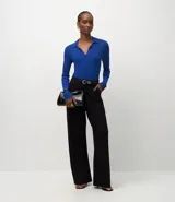 Blusa de manga larga con textura acanalada, cuello polo y escote en V. Confeccionada en tejido de viscosa y poliamida, presenta un corte regular que se ajusta de forma anatómica al cuerpo.