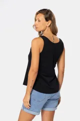 Musculosa blanca sin mangas, de corte clásico y calce cómodo, confeccionada en tejido suave. Presenta escote redondo, cartera con botones frontales y un pequeño bolsillo aplicado en el pecho.