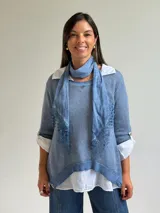 Sweater de punto color celeste con diseño asimétrico y detalle de encaje en el frente, acompañado por un pañuelo a juego.