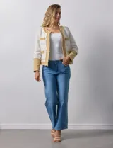 Chaqueta Nanette de tejido tweed y denim color blanco con cuello a la base y abertura central. Delantera con bolsillos, puño con aplique de botones metálicos y terminación desflecada.