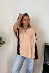 Remerón de manga corta, color beige claro, con bloques de color negro en las mangas. Presenta cuello redondo y un calce holgado.