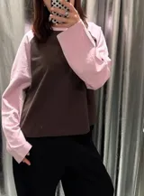 Remera oversize de manga larga estilo raglán, con cuerpo de color marrón y mangas y cuello en tono rosado.