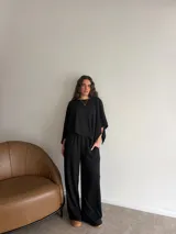 Conjunto de dos piezas de lanilla en color gris melange, compuesto por una blusa de corte amplio con mangas murciélago y escote bote, y un pantalón recto con bolsillos laterales.