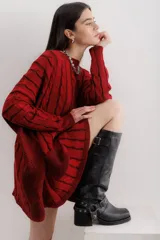 Bota bucanera de cuero color negro, con punta cuadrada, taco ancho y estribo desmontable con hebillas y tachas.