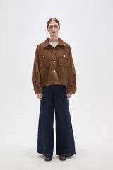 Sobrecamisa de pana color verde oliva oscuro, con cuello clásico, cierre frontal con botones metálicos y dos bolsillos delanteros con solapa y botón.