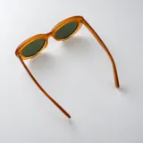 Lentes de sol con armazón ovalado de policarbonato en color negro brillante y cristales oscuros con protección UV400.