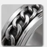 Anillo de acero italiano con diseño giratorio que presenta un motivo de cadena central.