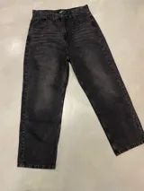 Pantalón de jean negro, corte amplio y tiro alto.