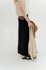 Pantalón blanco de lino y algodón, de tiro medio, con pinzas frontales, pretina ancha en la espalda con cambio de color y vivo en contratono, cortes en la mitad de la pierna de la espalda, cierre frontal con cierre y botón, y bolsillos delanteros.