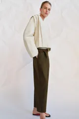 Pantalón cropped de tiro medio con diseño de pinzas en el delantero, trabillas para cinturón, bolsillos laterales y bolsillos de vivo en la parte trasera. Cierre frontal con cremallera y botón.