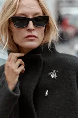 Chaqueta estilo bomber de punto color negro, con cuello subido, manga larga y cierre frontal cruzado con botones ocultos a presión. Presenta bolsillos delanteros de vivo.