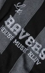 Sweater de punto con diseño a rayas verticales en negro y gris, cuello redondo y mangas largas. Presenta un estampado gráfico frontal con estilo deportivo retro que incluye el texto 'Ravers' y el número '90'. Cuenta con terminaciones en punto rib en cuello, puños y ruedo.