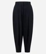 Pantalón de sarga de corte barrel, color negro, con pliegues en la cintura, piernas amplias y botamangas afinadas.