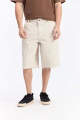 Bermuda carpenter de jean con corte amplio, bolsillos grandes y detalles inspirados en la ropa de trabajo. Presenta un lavado desgastado y ruedo desflecado.
