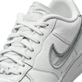 Championes Nike Air Force 1 Dance de corte bajo, confeccionados en cuero blanco con detalles texturizados. Presentan un diseño de swoosh lateral con acabado brillante y costuras visibles, manteniendo la estética clásica del modelo con suela de goma resistente.
