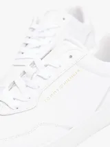 Zapatillas de cuero napa color blanco con diseño clásico de suela cupsole. Presentan cierre de cordones, forro de poliéster y logos de la marca Tommy Hilfiger en relieve metalizado en el lateral, la lengüeta y el talón.