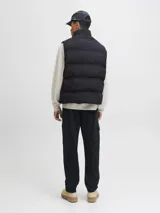 Chaleco puffer de cuello alto con cierre frontal de cremallera, confeccionado en tejido técnico acolchado con acabado liso.